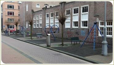 Детские игровые сооружения вдоль дороги и стены дома