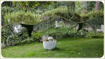 Зеркало неправильной формы в ограждении сада