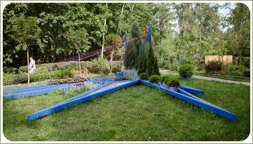 Синие треугольники и растения на лужайке