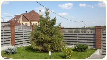 Ель на входе. Ландшафтный дизайн в Челябинске — 2014 Ель и хвойные и бело цветущие растения на фоне лужайки и забора