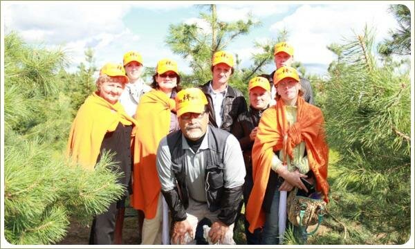 Семинар ниваки. Групповой снимок Группа мужчин и женщин на фоне растений