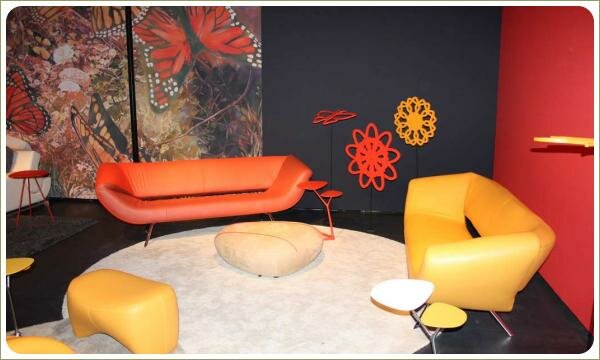 контрастный красно-черный интерьер с желтым креслом и оранжевым диваном, стена с изображением цветов