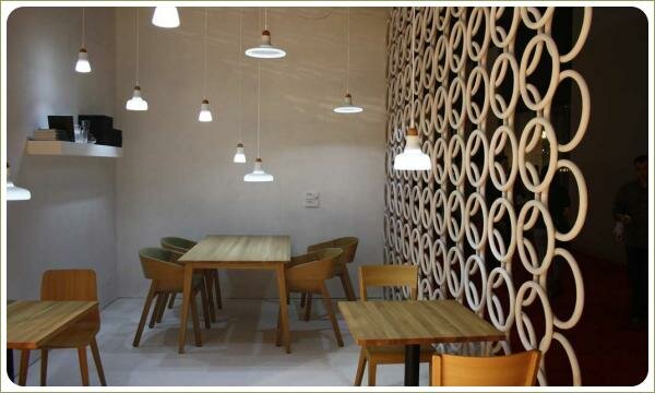 белый интерьер, деревянная мебель, столовая зона, справа перегородка из круглых элементов