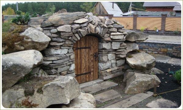 Маленькая дверь в окружении камней и ступени