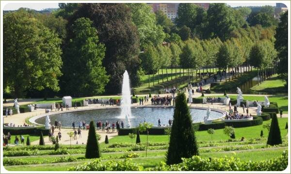 Круглый водоём с фонтаном и аллеи и виноградники и топиари и статуи богов