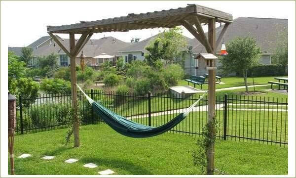 Уютный гамак: на конструкции Гамак на деревянных опорах с крышей на фоне садового участка