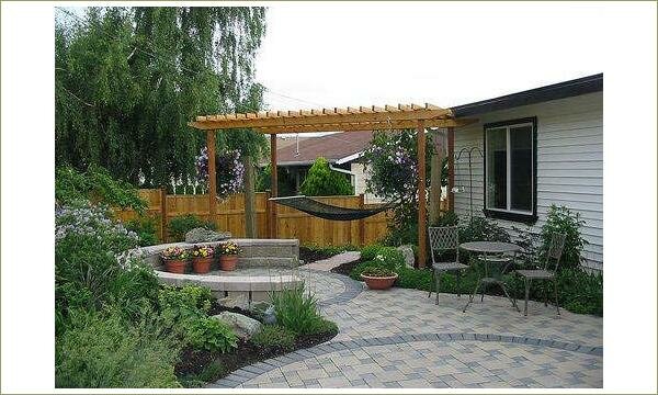 Пергола с гамаком и мощёная площадка с садовой мебелью