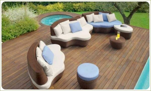 Деревянная терраса у воды с набором современной плетёной мебели 