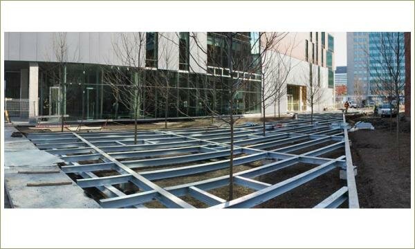 металлические конструкции для устройства будущего дорожного покрыти и ереья на фоне офисного зданияя