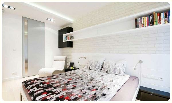 Белая спальня с кирпичной стеной Светлая комната с большой кроватью и цветным покрывалом