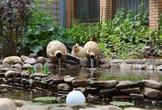 Небольшой прудик и амфоры с вытекающей водой