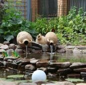 Небольшой прудик и амфоры с вытекающей водой
