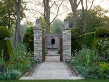 Дорожка и столбы и скульптцра и миксбордеры со стриженными в пирамиды тисами