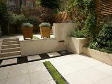 Лестница и белый камень в мощении и маленький вооём с изливом и растения с серебристой литвой