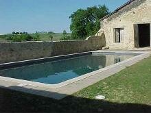 прямоугольный бассейн на фоне разрушенной стены и строения и газона