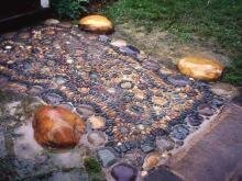 дорожка с мозаикой из мелкой речной разноцветной галки и крупные валуны и зелень