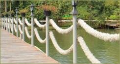 Декоративный мостик через водоём с перилами из каната 