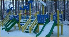 Детский игровой комплекс на лесной опушке в снегу