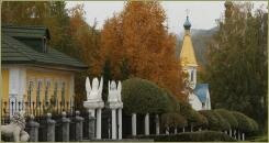 Trees with autumn colored foliage and small bright houses along the roadway