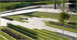 Прямоугольные длинные клумбы с газоном и цветами на фоне мощения плитами и площадки и лестницы