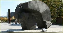 Каменная глыба — современная скульптура в Сеуле Большой серый обтёсанный камень на площадке