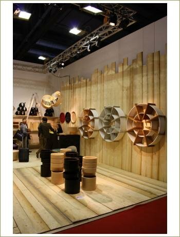 Деревянные стеллажи, в виде спирали, табуреты из дерева разной формы, черные и бежевые