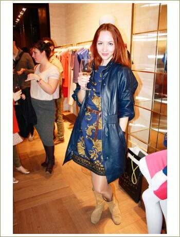 Девушка стоит с бокалом шампанского в магазина одежды