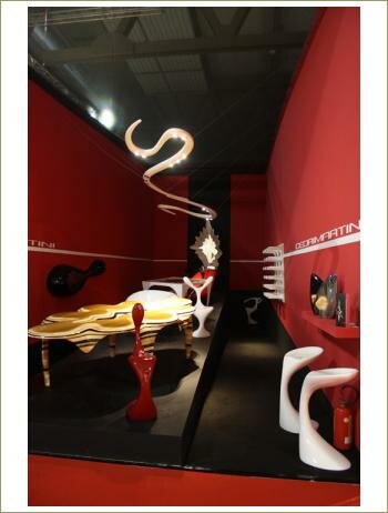 черный пол и потолок, красные стены, на фоне стулья и светильники причудливых форм - футуристичный интерьер