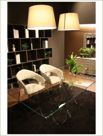 стеклянный столик, два белых кресла, над ними два абажура, на фоне книжного стеллажа черного цвета