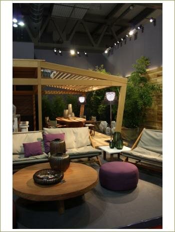 Интерьер террасы, беседка из дерева, низкий круглый стол, фиолетовый пуфик, белые кресла, деревья в кадках