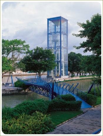 Синий мост через речку и стриженные кустарники и застеклённая конструкция