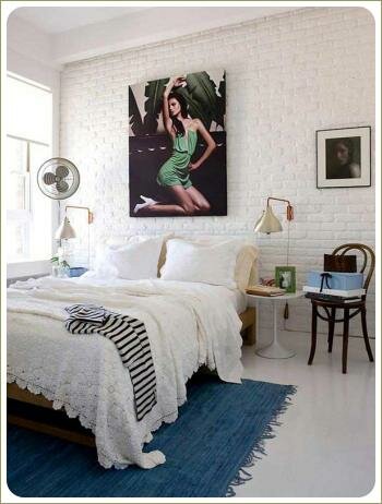 Стена из камня в спальне Светлая спальня с большой кроватью и синим ковром и белая стена из камня